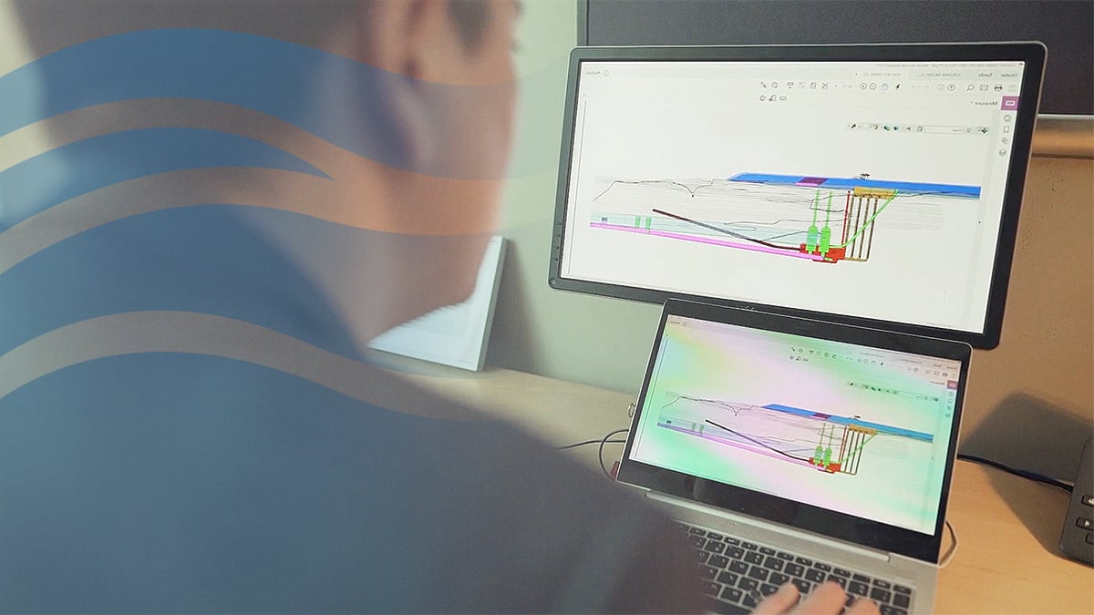 Engineer looking at computer screens showing a schematic below-ground design for the project.